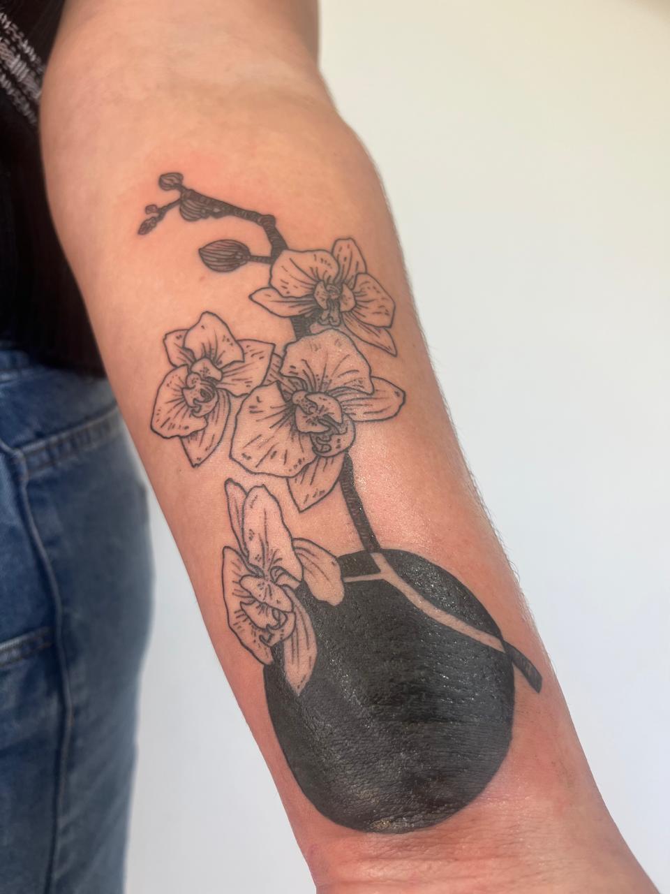 Tatuaje de línea fina floral en antebrazo